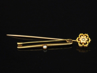 Vente aux enchères Petite broche barrette en or jaune 750, sertie en son centre d'une per