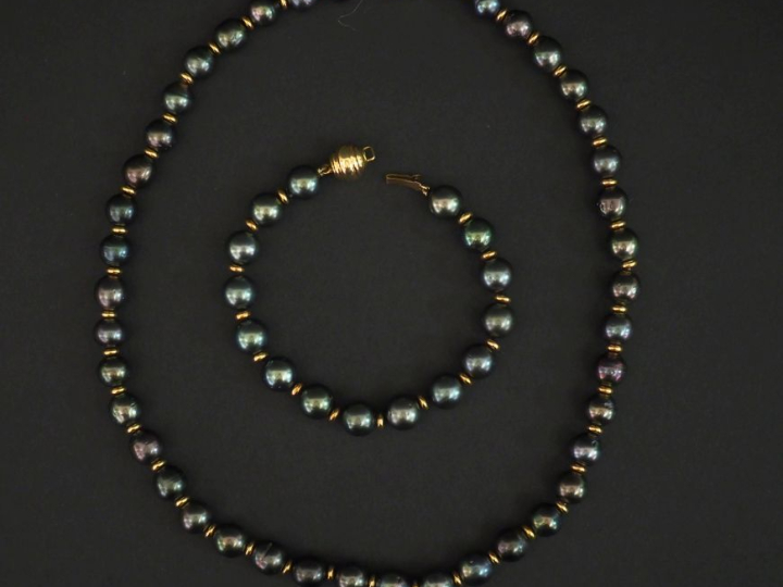 Demi parure comprenant un collier et un bracelet de perles grises et m