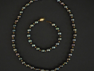 Vente aux enchères Demi parure comprenant un collier et un bracelet de perles grises et m