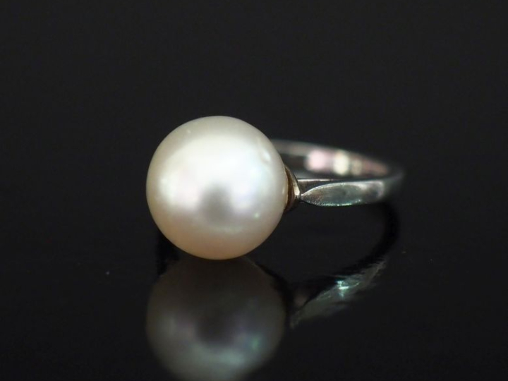Bague en or blanc 750, sertie en son centre d'une perle blanche.  TDD.