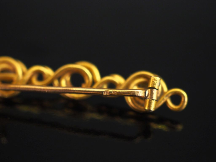Petite broche barette en or jaune 750, à décor ajouré d'entrelacs et s