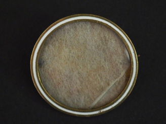 Vente aux enchères Broche circulaire porte-photo en métal doré et émail blanc.  Pique en 