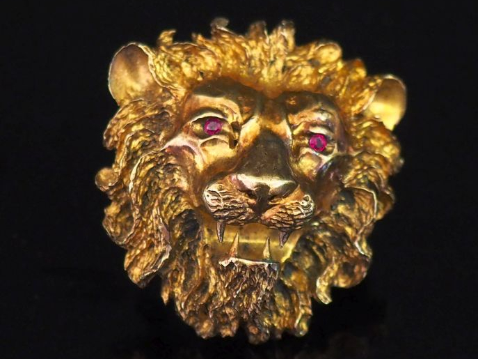 Broche en métal doré, figurant un lion.  Les yeux sertis de pierres ro