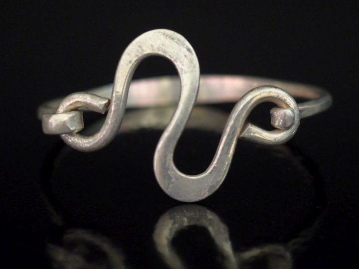 Bracelet jonc en argent, à décor en son centre d'un motif abstrait.  P