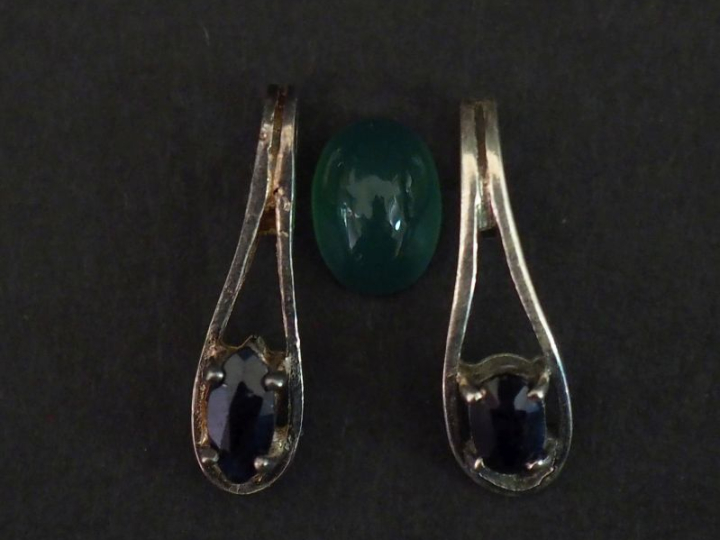 Deux pendentifs en argent, sertis d'une pierre bleue.  H. 1,7 cm Poids