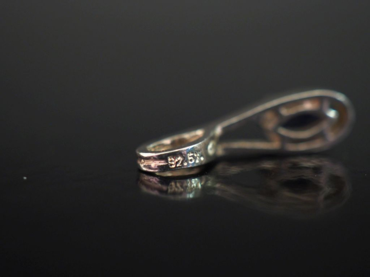 Deux pendentifs en argent, sertis d'une pierre bleue.  H. 1,7 cm Poids