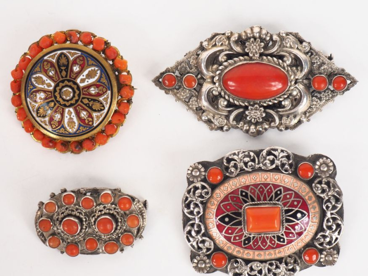 4 différentes broches en métal argenté, émail et cobochons de corail. 