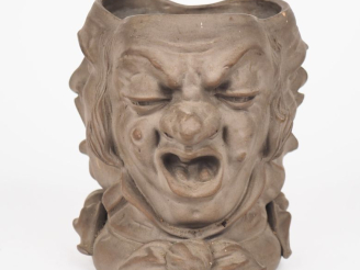 Vente aux enchères SARREGUEMINES. Pot à tabac en terre cuite à décor de trois visages d'h