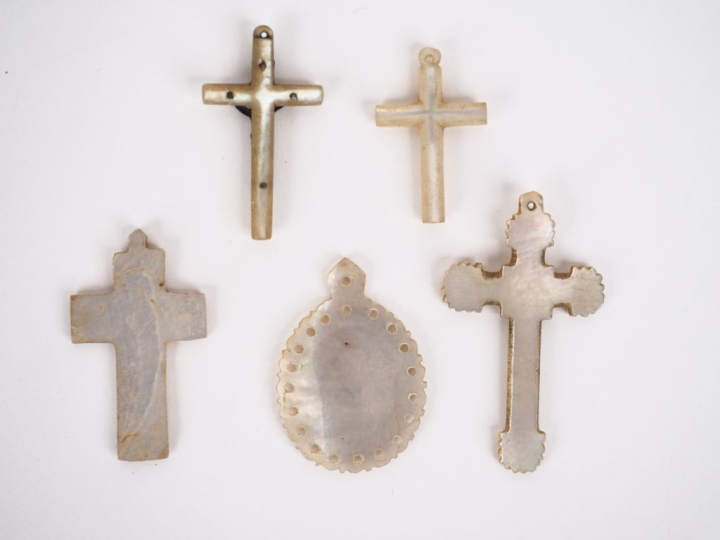 4 différentes croix et une médaille religieuse en nacre. H. de 3 à 4,5