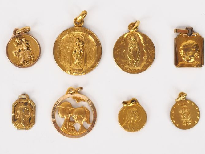 12 différentes médailles religieuses en métal doré ou plaqué.