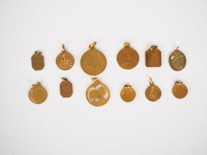12 différentes médailles religieuses en métal doré ou plaqué.