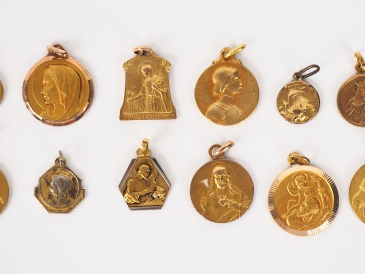 12 différentes médailles religieuses en métal doré ou plaqué.
