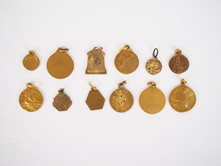 12 différentes médailles religieuses en métal doré ou plaqué.