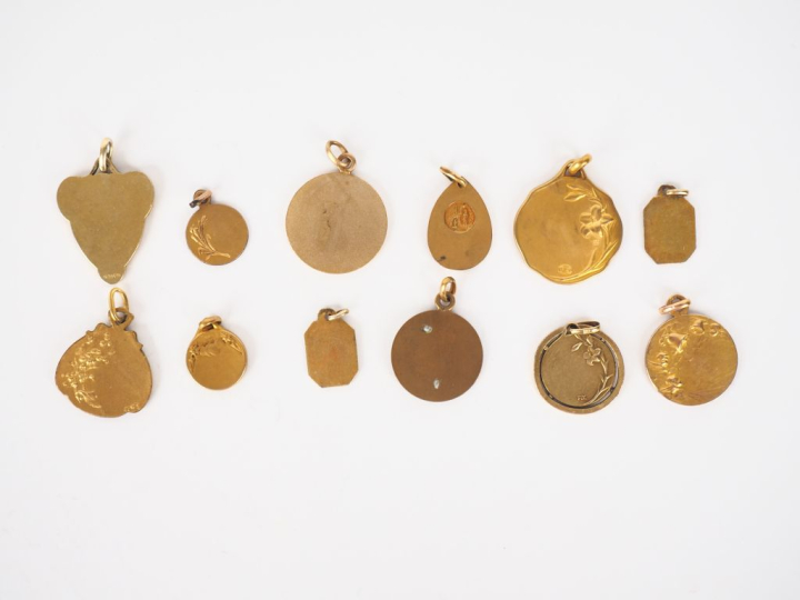 12 différentes médailles religieuses en métal doré ou plaqué.