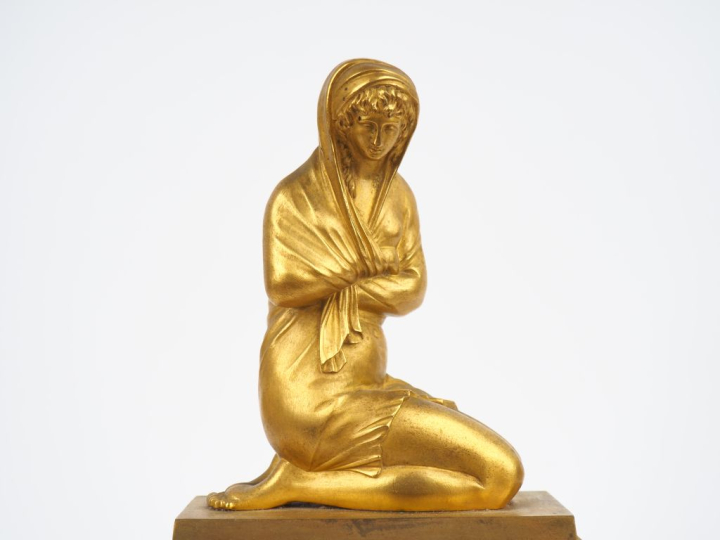 Pendule borne Empire en bronze à patine verte et dorée représentant un