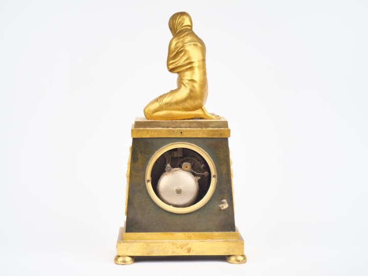 Pendule borne Empire en bronze à patine verte et dorée représentant un