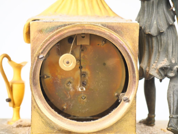 Pendule d'alcove début XIXème en bronze patiné ét doré, décor de femme