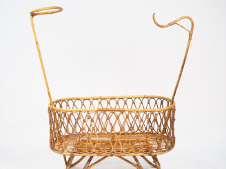 Vente aux enchères Berceau des années 70, en rotin avec ses accessoires.
