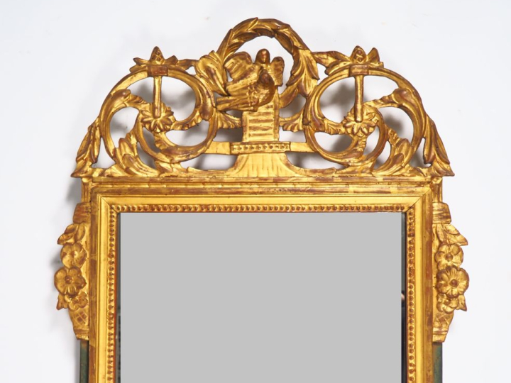Miroir de style Louis XVI en bois sculpté et doré, fronton ajouré à dé