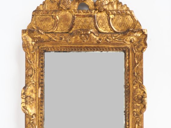 Miroir fin XVIIIème en bois sculpté et doré à décor de rocaille, de fl