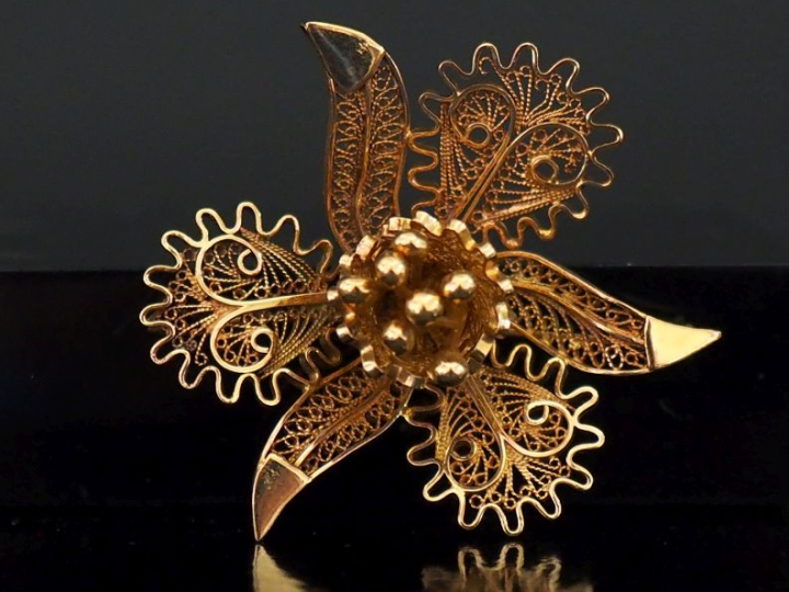 Broche en forme de fleur épanouie, à décor ajouré et filigrané.  4,2 x