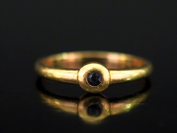 Petite bague en or jaune 750, ornée en son centre d'une pierre noire s