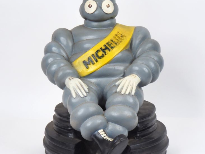 MICHELIN.  Grand sujet en résine, bibendum assis sur un pneu.  Dim. 49