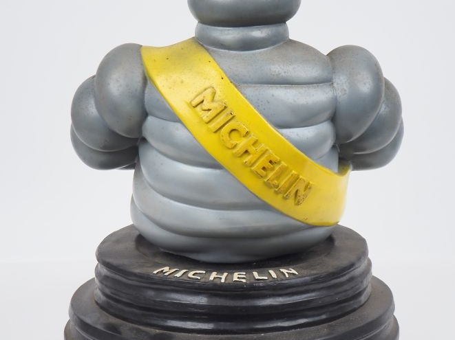 MICHELIN.  Grand sujet en résine, bibendum assis sur un pneu.  Dim. 49