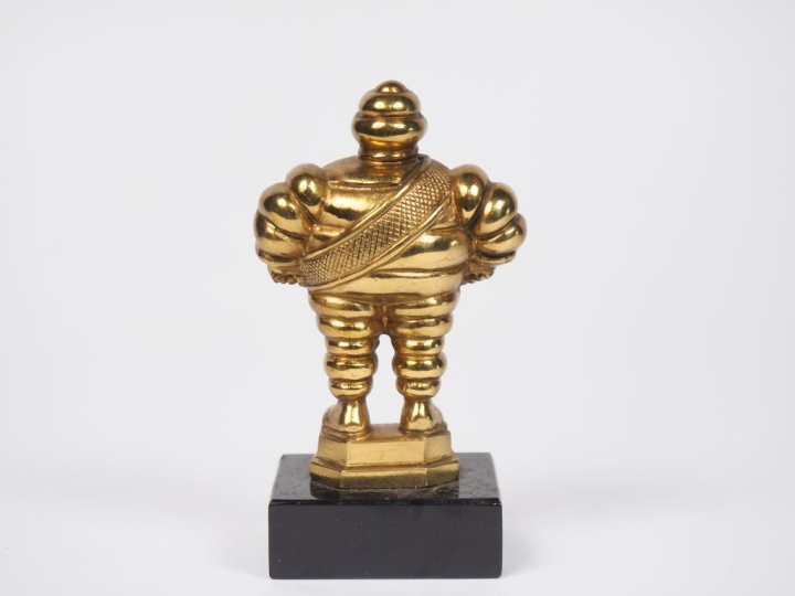 MICHELIN.  Bibendum, sujet en bronze doré sur un socle en marbre noir.