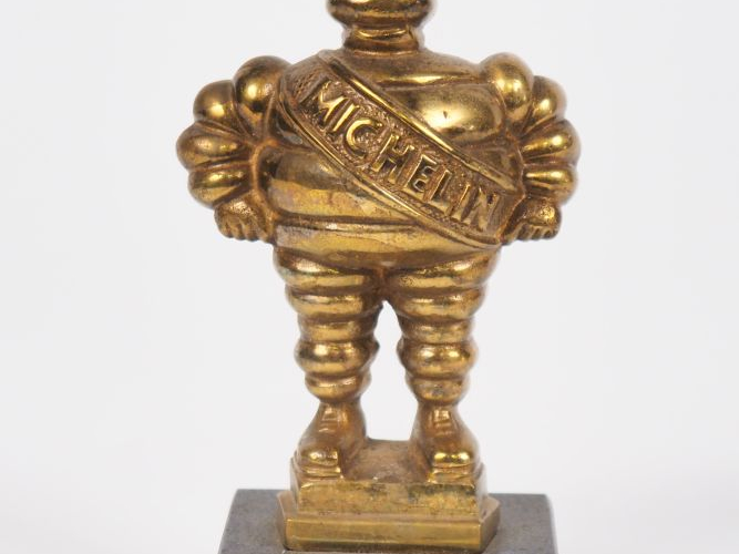 MICHELIN.  Bibendum, sujet en bronze doré sur un socle en marbre noir.