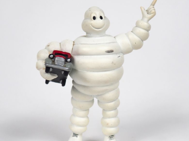 MICHELIN. Bibendum, sujet en plastique rigide tenant un camion rouge d