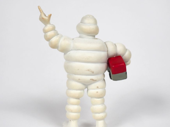 MICHELIN. Bibendum, sujet en plastique rigide tenant un camion rouge d
