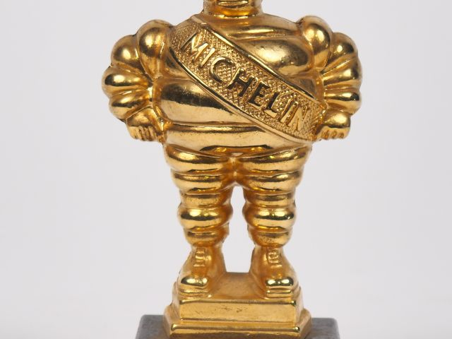 MICHELIN.  Bibendum, sujet en bronze doré sur un socle en marbre noir.