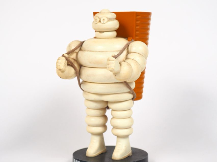 MICHELIN.  Porte crayon Bibendum vendangeur en plastique et métal. H. 