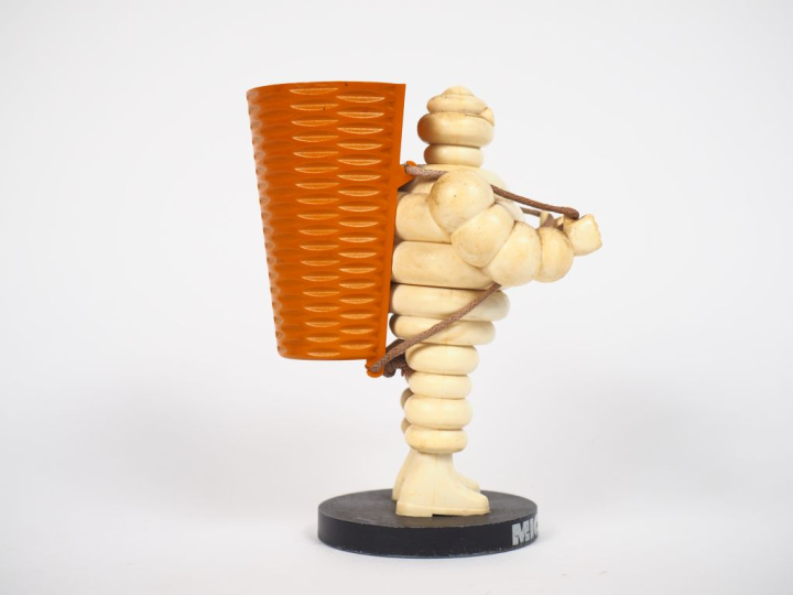 MICHELIN.  Porte crayon Bibendum vendangeur en plastique et métal. H. 
