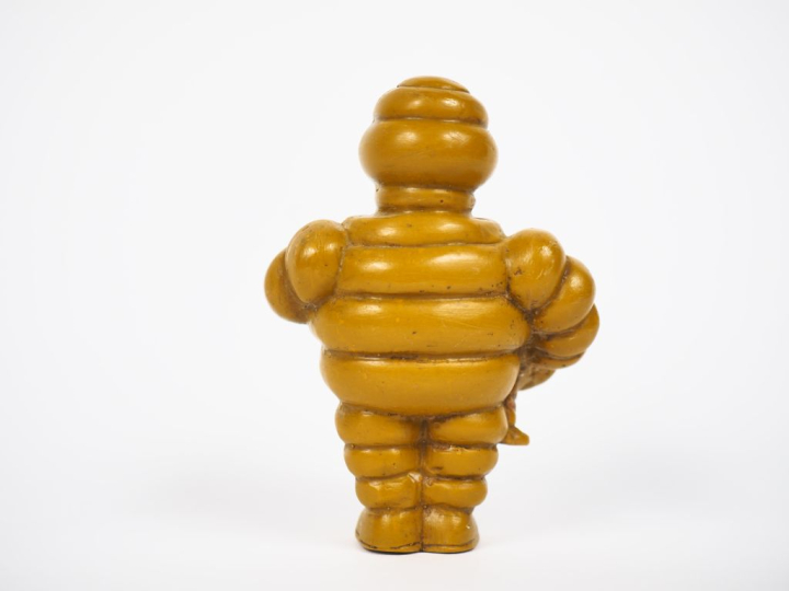 MICHELIN. Bibendum, sujet en résine jaune. H. 9,5 cm.