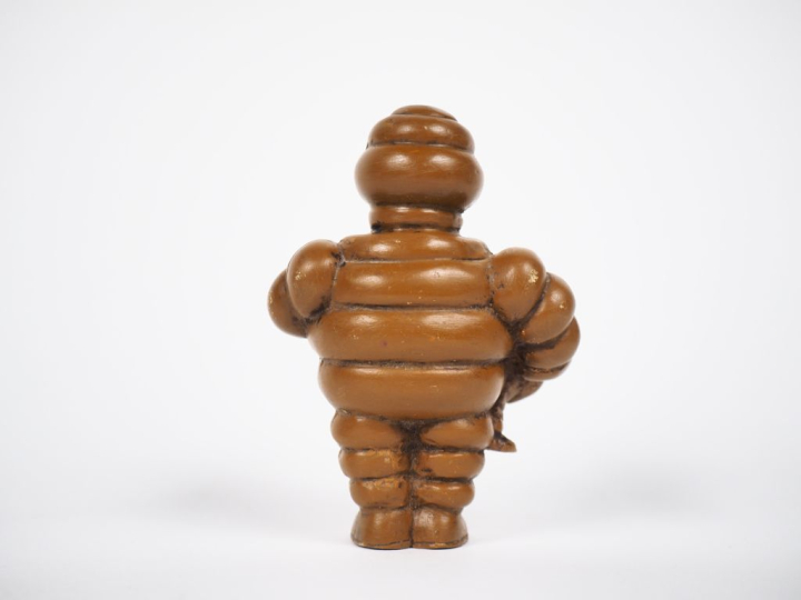 MICHELIN. Bibendum, sujet en résine ocre. H. 9,5 cm.