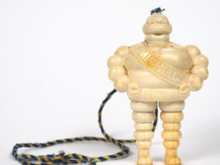 MICHELIN. Bibendum stylo, sujet en plastique rigide. H. 10,5 cm.