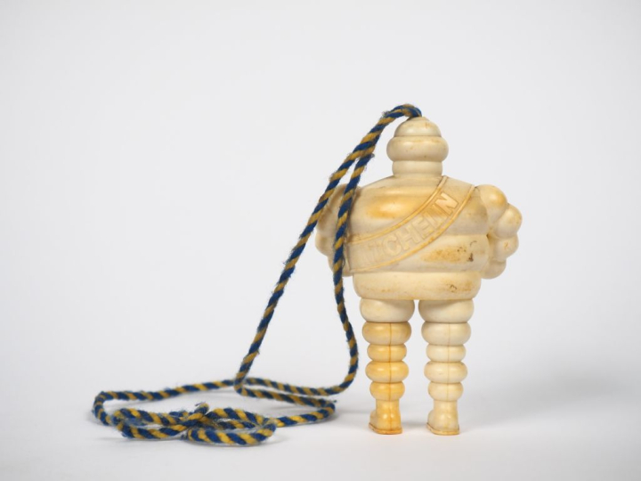 MICHELIN. Bibendum stylo, sujet en plastique rigide. H. 10,5 cm.