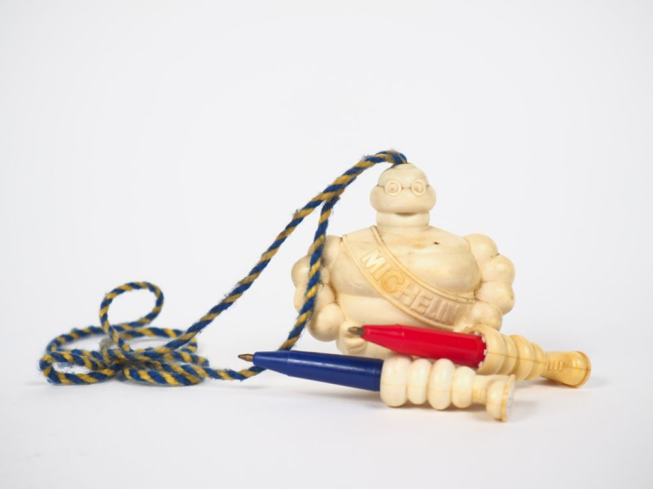 MICHELIN. Bibendum stylo, sujet en plastique rigide. H. 10,5 cm.