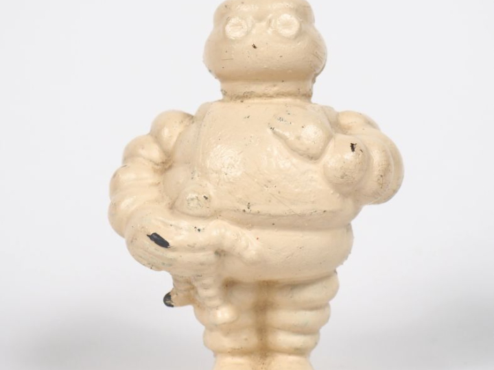 MICHELIN. Bibendum, sujet en fonte blanc. H. 9,5 cm.