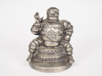 Vente aux enchères MICHELIN.  Sujet bibendum en métal assis sur des pneus.