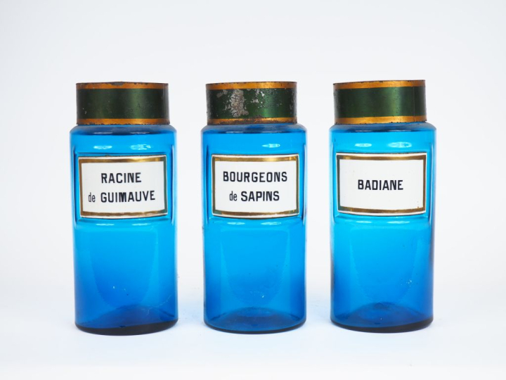 Suite de 3 pots de pharmacie en verre bleu et émail, couvercle en tôle