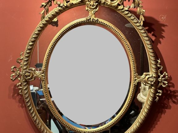 Glace médaillon à parecloses de style Louis XVI en bois et stuc doré, 