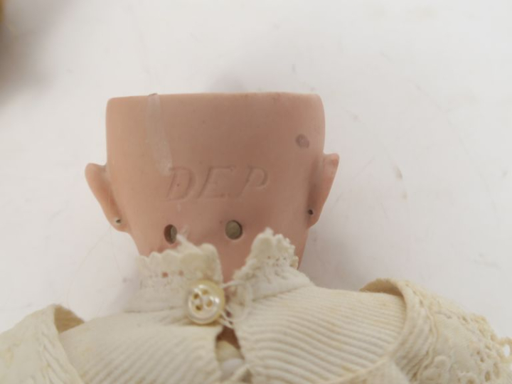 Lot comprenant petite poupée de marque Dep bouche ouverte yeux bascula