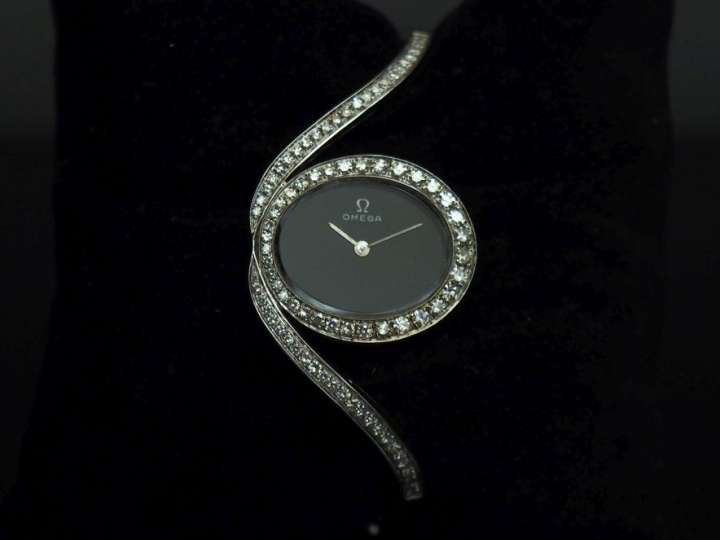 OMEGA Montre bracelet de dame en or blanc 750 et diamants.  Cadran ova