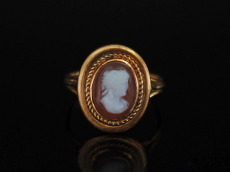 Vente aux enchères Bague en or jaune 750, sertie en son centre un camée figurant une jeun