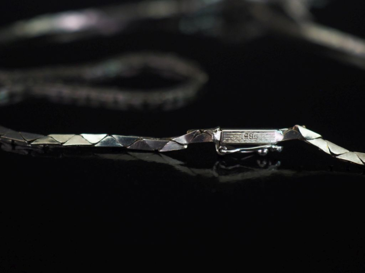 Collier souple en or blanc 585, à décor en son centre d'un motif styli