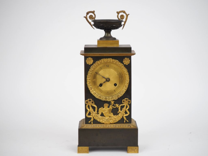 Pendule borne Restauration en bronze patiné et doré, à décor d'amours 