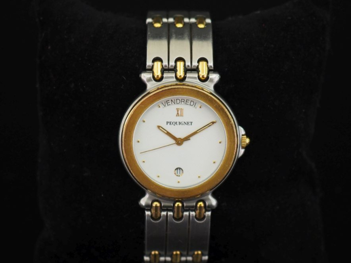 PEQUIGNET,  Montre bracelet en acier. Cadran à fond blanc et pastilles